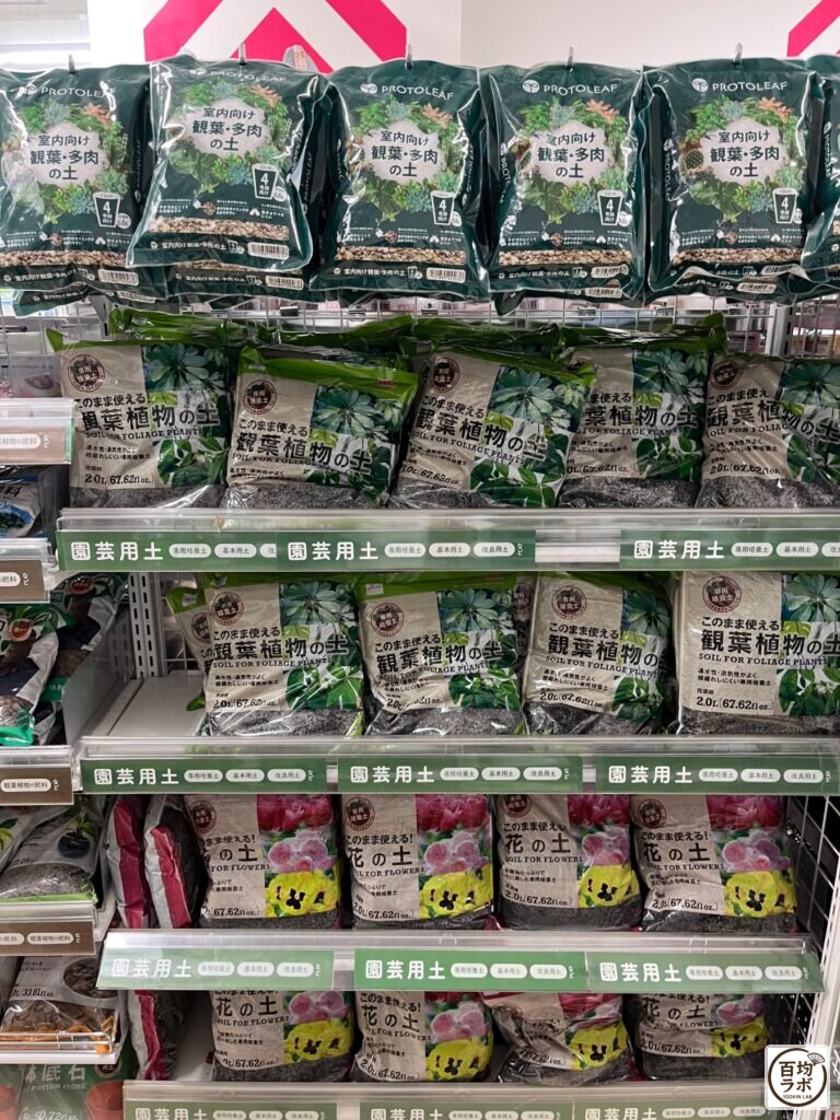 ダイソー 大崎店のアウトドア売り場に並ぶ室内向け観葉・多肉の土、観葉植物の土など計3商品（2026年8月29日撮影）