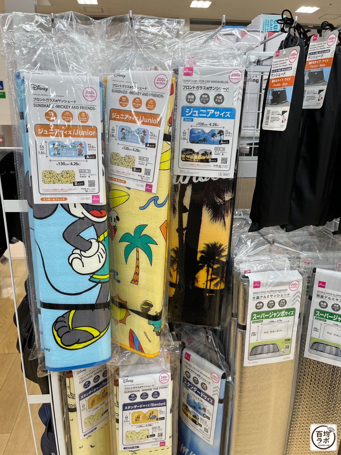 ダイソー 東戸塚の収納売り場に並ぶフロントガラス用サンシェード（ミッキー＆フレンズ・ジュニアサイズ）、フロントガラス用サンシェード（ジュニアサイズ）など計6商品（2026年8月11日撮影）