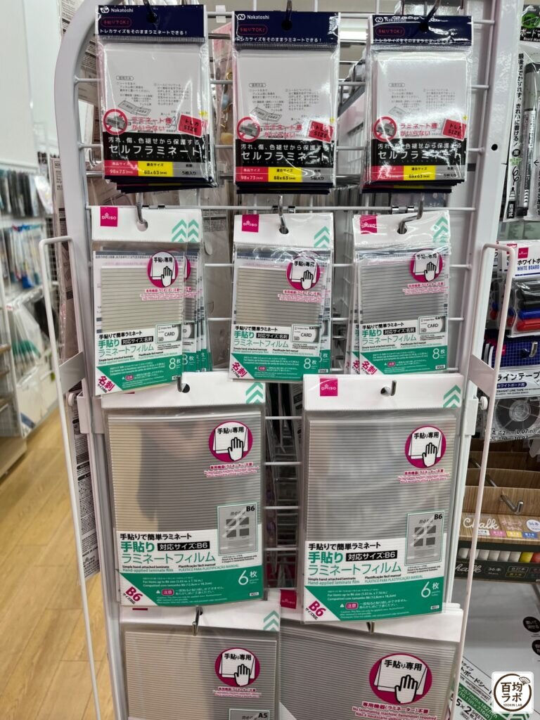 ダイソー 東戸塚の文房具売り場に並ぶセルフラミネートフィルム（名刺サイズ）、手貼りラミネートフィルム（名刺サイズ）など計3商品（2026年8月11日撮影）