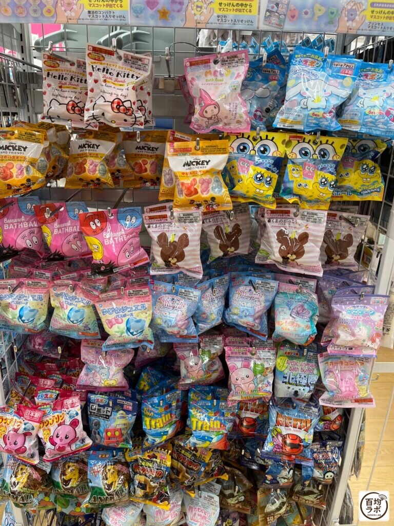 ダイソー 東戸塚の掃除・洗濯売り場に並ぶシナモロール バスボム、マジカルコンパクト バスボムなど計17商品（2026年8月11日撮影）