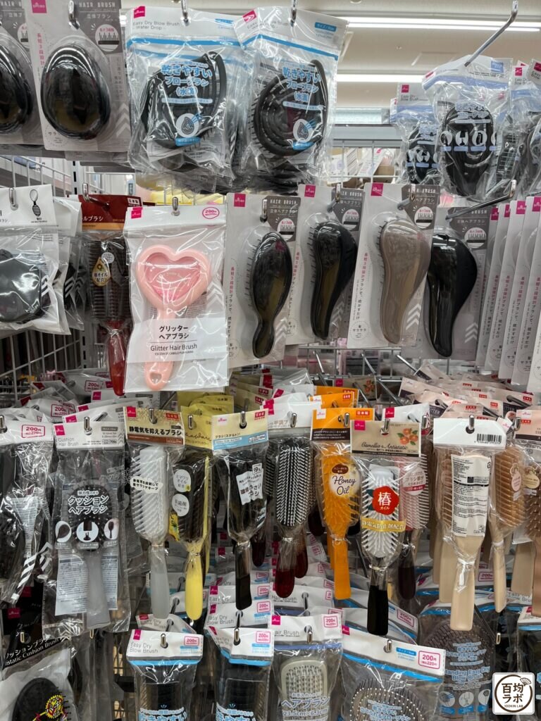 ダイソー 東戸塚の掃除・洗濯売り場に並ぶ立体ヘアブラシ、乾きやすいブローブラシ（水滴）など計11商品（2026年8月11日撮影）