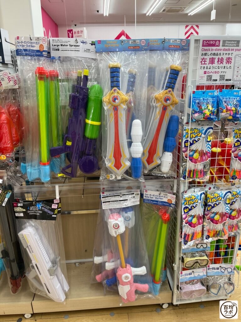 ダイソー 東戸塚のアウトドア売り場に並ぶウォーターガン（ショットガン）、大型水鉄砲など計7商品（2026年8月11日撮影）