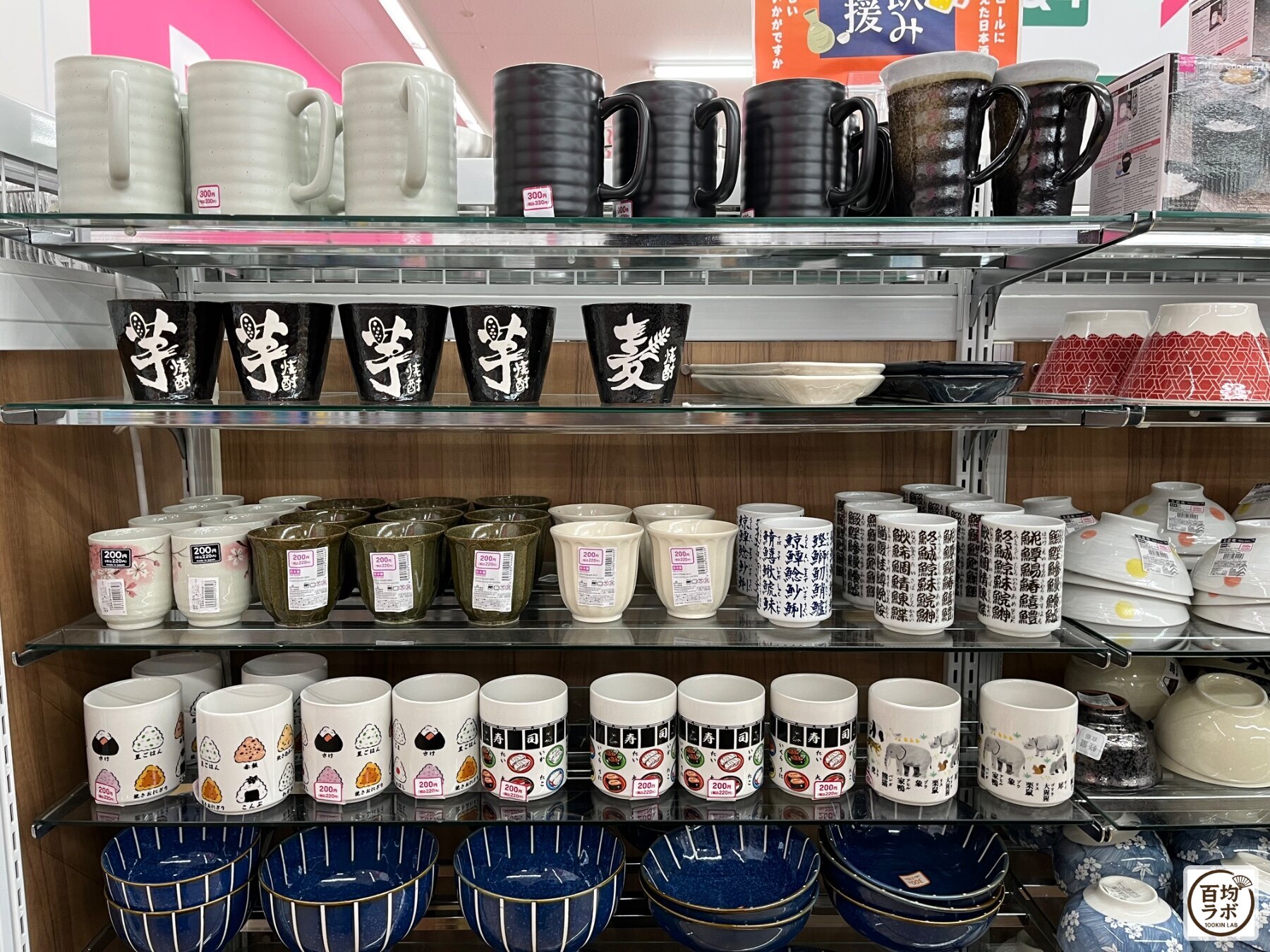ダイソー 東戸塚のキッチン売り場に並ぶマグカップ（白）、マグカップ（黒）など計20商品（2026年8月12日撮影）