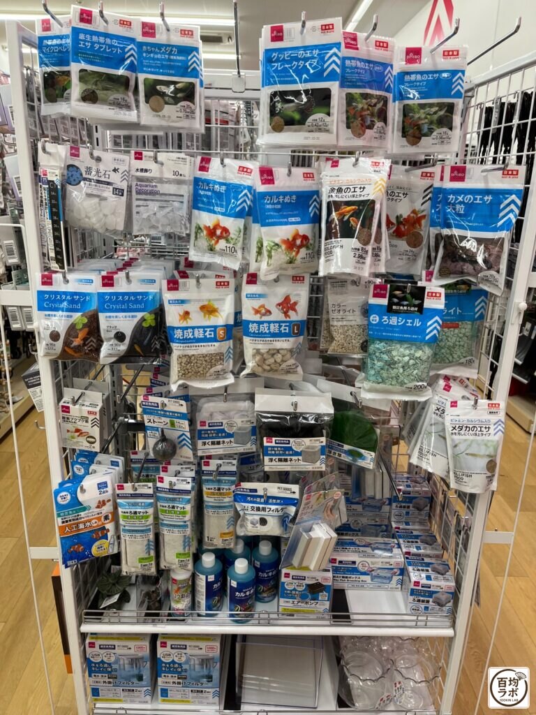 ダイソー 東戸塚の電池・電気小物売り場に並ぶ底生熱帯魚のエサ タブレット、赤ちゃんメダカ・キンギョのエサなど計20商品（2026年8月12日撮影）