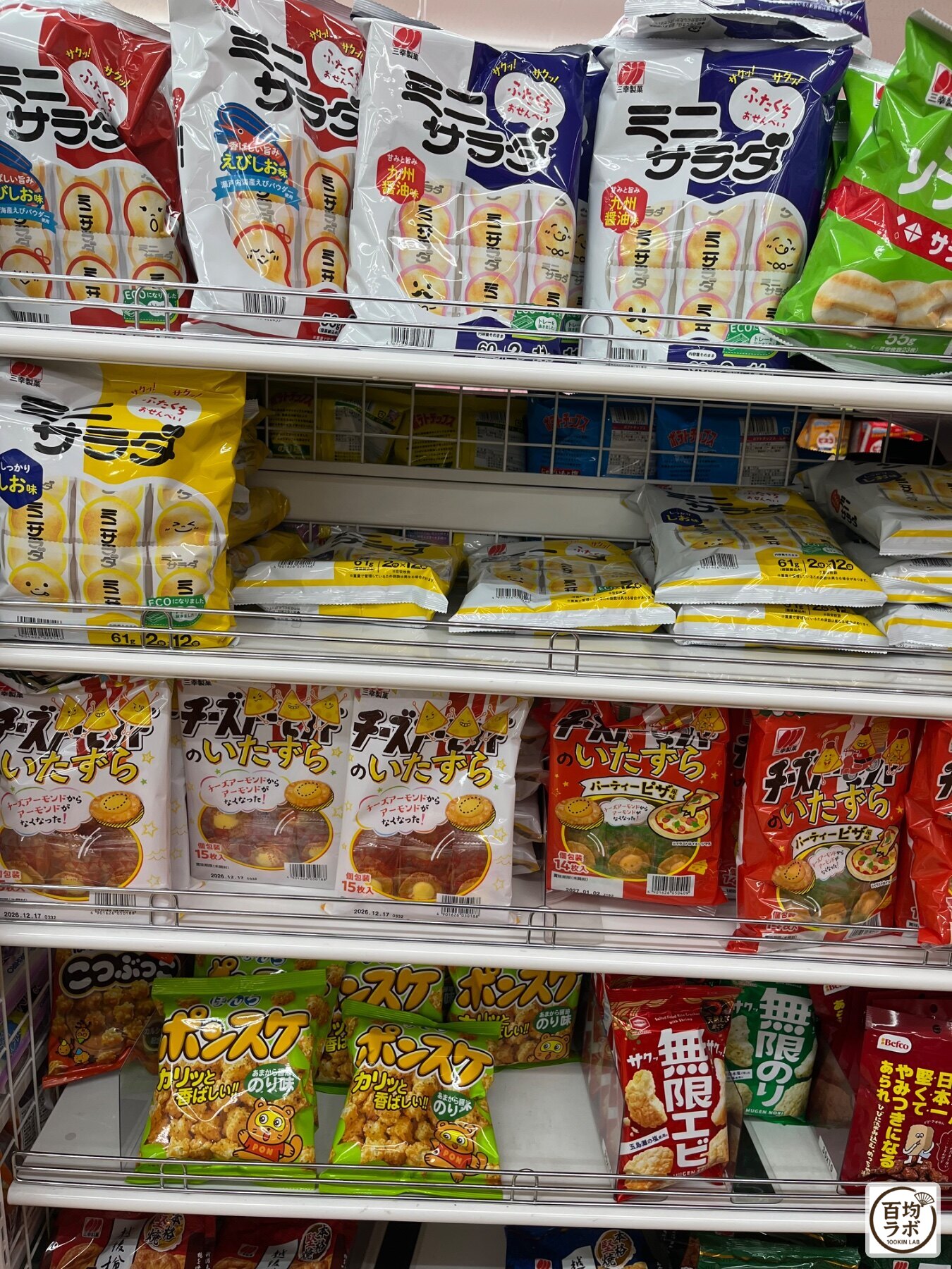 ダイソー 東戸塚の食品・飲料売り場に並ぶミニサラダ（えび塩味・九州醤油味・しお味）、チーズのいたずらなど計10商品（2026年8月12日撮影）