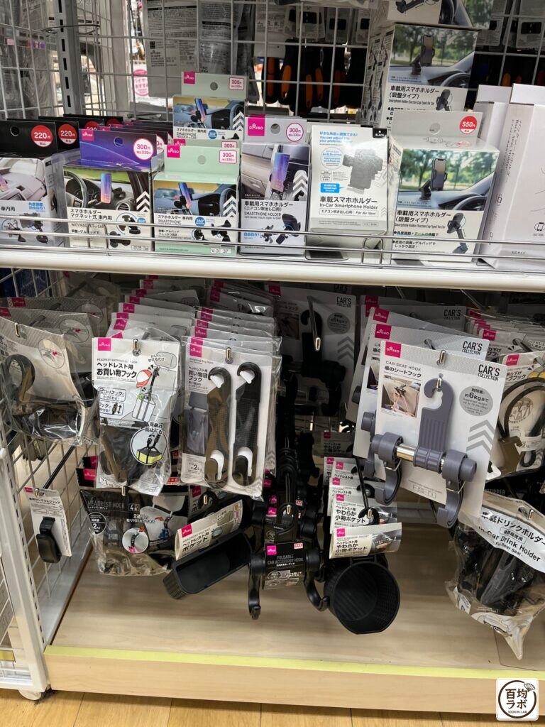 ダイソー 東戸塚のスマホ用品売り場に並ぶ車載用スマホホルダー（吸盤タイプ）、車載用スマホホルダー（エアコン吹き出し口用）など計9商品（2026年8月13日撮影）