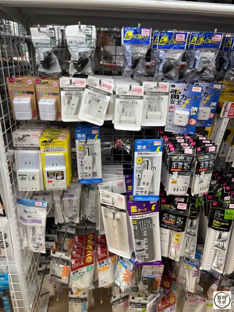 ダイソー 東戸塚の電池・電気小物売り場に並ぶ海外用変換プラグ、4個口マイクロタップなど計16商品（2026年8月14日撮影）