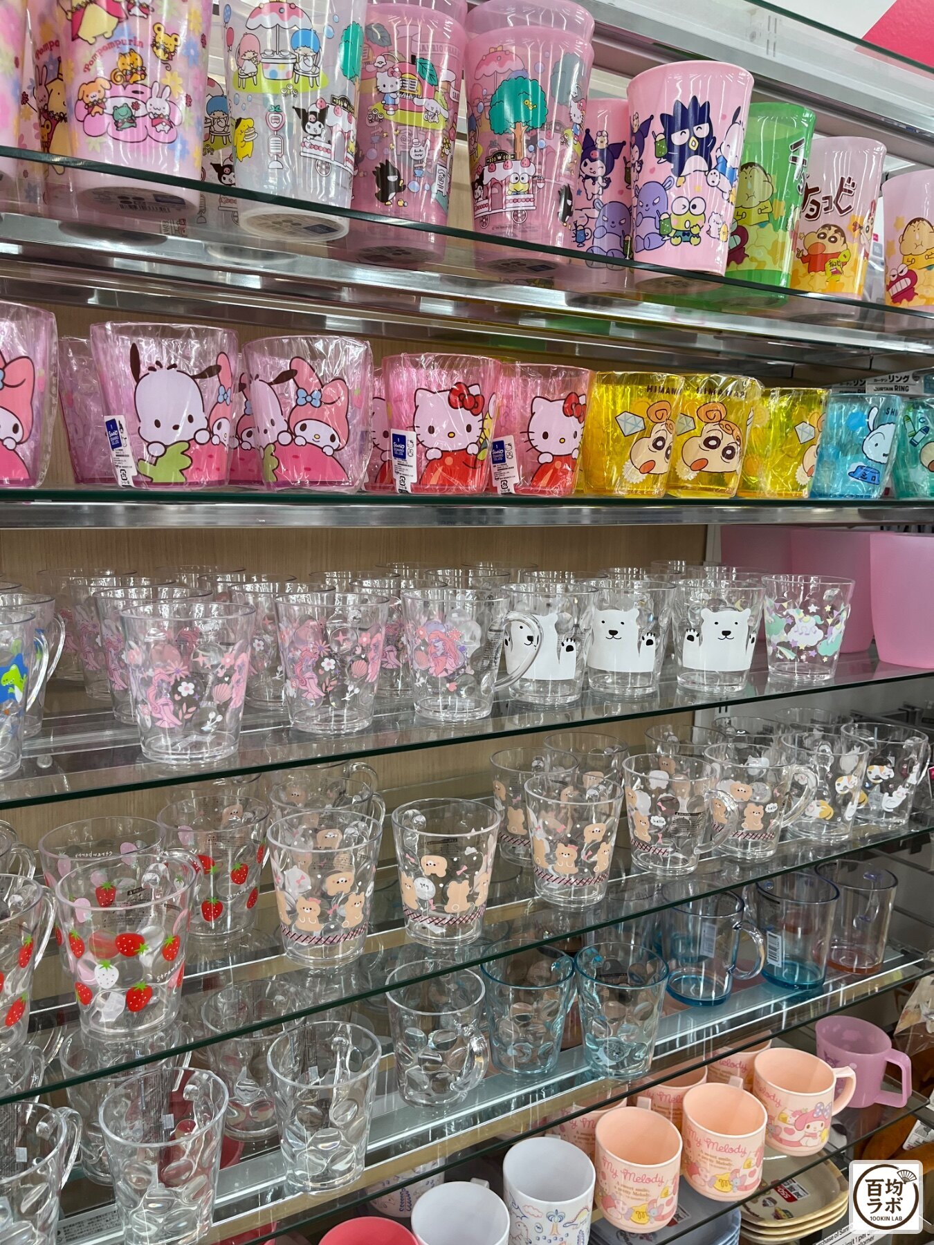 ダイソー 東戸塚のキッチン売り場に並ぶサンリオキャラクター柄プラスチックコップ、クレヨンしんちゃん柄プラスチックコップなど計10商品（2026年8月14日撮影）