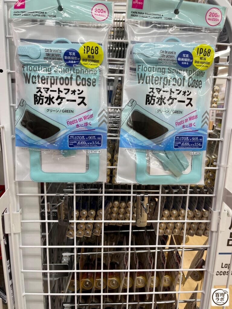 ダイソー 東戸塚のスマホ用品売り場に並ぶスマートフォン防水ケース（グリーン）（2026年8月14日撮影）