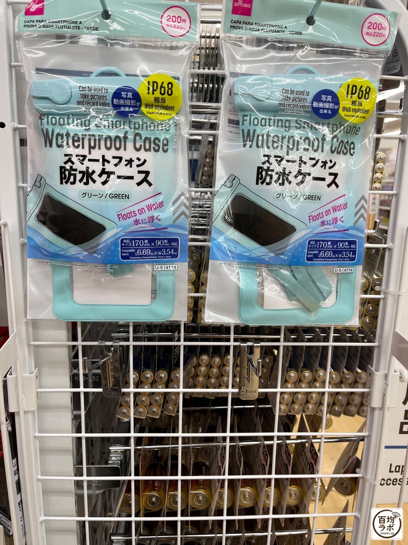 ダイソー 東戸塚のスマホ用品売り場に並ぶスマートフォン防水ケース（グリーン）（2026年8月14日撮影）